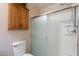 Bathroom featuring a toilet, shower-tub combo with a glass door and oak cabinet at 1520 N Milly Pl, Casa Grande, AZ 85122