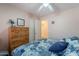 Cozy bedroom featuring a wooden dresser, ceiling fan, and a comfortable bed with patterned bedding at 1520 N Milly Pl, Casa Grande, AZ 85122