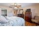 Cozy bedroom featuring a ceiling fan, wood floors, and ensuite closet access at 1520 N Milly Pl, Casa Grande, AZ 85122