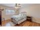 A bedroom with hardwood floors, ceiling fan, and large window for natural light at 1520 N Milly Pl, Casa Grande, AZ 85122