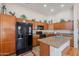 A kitchen with stainless steel appliances, wooden cabinets, and an island with a sink at 1520 N Milly Pl, Casa Grande, AZ 85122