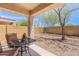 Relaxing covered patio featuring a table, chairs, and view of the backyard landscaping at 1520 N Milly Pl, Casa Grande, AZ 85122