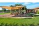 Community playground featuring shaded play equipment, seating, and a grassy area at 15421 S 16Th Dr, Phoenix, AZ 85045