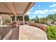 Covered patio with stone flooring and decorative knee wall overlooks native desert landscaping at 15534 W Big Sky Dr, Surprise, AZ 85374