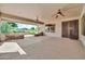 Large covered patio features golf course view, ceiling fans, and decorative iron door at 15534 W Big Sky Dr, Surprise, AZ 85374