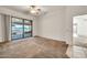 Spacious bedroom with carpet flooring, ceiling fan, and sliding glass door leading to outdoor patio at 15534 W Big Sky Dr, Surprise, AZ 85374