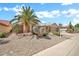 Charming single-Gathering home with desert landscaping, palm trees, cacti, and a well-maintained lawn at 15534 W Big Sky Dr, Surprise, AZ 85374