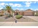 Lovely single-Gathering home featuring desert landscaping, a two-car garage, and a lush, green lawn at 15534 W Big Sky Dr, Surprise, AZ 85374