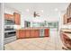 Kitchen featuring modern appliances, wooden cabinets, tile flooring, and open layout at 15534 W Big Sky Dr, Surprise, AZ 85374
