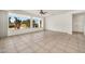 Spacious living room with tile floors, large windows, and a ceiling fan at 15534 W Big Sky Dr, Surprise, AZ 85374
