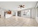Open-concept living room featuring neutral tile flooring, a breakfast bar and large windows at 15534 W Big Sky Dr, Surprise, AZ 85374