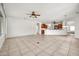 Spacious living room with ceiling fan and tile floors leads to kitchen with breakfast bar at 15534 W Big Sky Dr, Surprise, AZ 85374