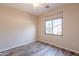 Bright bedroom features wood-look floors, ceiling fan, and large window with neighborhood views at 1555 E Monterey St, Chandler, AZ 85225