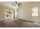 Spacious bedroom featuring neutral carpet, ceiling fan, and a sliding glass door leading to a covered patio at 1555 E Monterey St, Chandler, AZ 85225