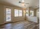Bright living room featuring wood floors, ceiling fan, and access to the backyard through a glass-paneled door at 1555 E Monterey St, Chandler, AZ 85225