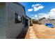 Exterior view of the home, showcasing the stucco siding, covered patio, and landscape with stepping stones at 161 S Maple St, Chandler, AZ 85226