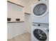 Bright laundry room with stacked washer and dryer at 17345 W Smoketree Dr, Surprise, AZ 85387