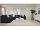 Cozy living room featuring a plush sofa, neutral decor, and ample natural light at 17348 W Smoketree Dr, Surprise, AZ 85387