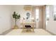 Bright home office features a desk, chair, large window and plant that create a productive and calming work space at 17348 W Smoketree Dr, Surprise, AZ 85387