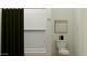 Clean, bright bathroom with a tub/shower featuring a dark green shower curtain at 17349 W Smoketree Dr, Surprise, AZ 85387