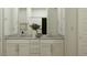 Bright bathroom featuring double sinks, granite countertops, and white cabinets at 17349 W Smoketree Dr, Surprise, AZ 85387