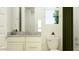Well-lit bathroom with vanity, granite countertop, toilet, and decorative plants at 17349 W Smoketree Dr, Surprise, AZ 85387