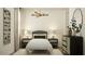 This bedroom has minimalist decor, with matching side tables, lamps and a full-length mirror at 17349 W Smoketree Dr, Surprise, AZ 85387
