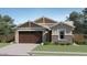 Charming single-story home featuring a stone facade accent, a two-car garage, and manicured landscaping at 17349 W Smoketree Dr, Surprise, AZ 85387