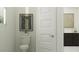 Cozy half-bath with decorative painting, white toilet, and dark cabinets at 17403 W Swayback Pass, Surprise, AZ 85387