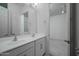 Bright bathroom featuring double sinks, white cabinetry, and a view to the bedroom at 18135 W Hope Dr, Goodyear, AZ 85338