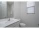 Well-lit bathroom with a modern sink, vanity, and toilet, complemented by a shower and a large mirror at 18135 W Hope Dr, Goodyear, AZ 85338
