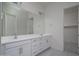 Bathroom featuring double sinks, white cabinets and modern hardware at 18135 W Hope Dr, Goodyear, AZ 85338