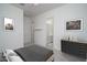 Staged bedroom showcasing artwork, furnishings, and a view to the ensuite bathroom at 18135 W Hope Dr, Goodyear, AZ 85338