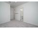 Bright bedroom with neutral carpet, ceiling fan, and a view into the ensuite bathroom at 18135 W Hope Dr, Goodyear, AZ 85338
