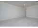 Empty bedroom featuring neutral carpet, an open layout and modern ceiling fan at 18135 W Hope Dr, Goodyear, AZ 85338
