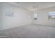 Spacious bedroom with neutral carpet, multiple windows and modern ceiling fan at 18135 W Hope Dr, Goodyear, AZ 85338