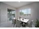Bright dining room featuring a table set for six with a view of the lake and pool at 18135 W Hope Dr, Goodyear, AZ 85338