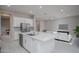 Modern kitchen with a large island, stainless steel appliances, white cabinetry, and an open layout at 18135 W Hope Dr, Goodyear, AZ 85338