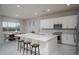 Modern kitchen with white cabinets, stainless steel appliances, and a large island with a quartz countertop and seating at 18135 W Hope Dr, Goodyear, AZ 85338