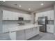 Bright kitchen featuring white cabinets, stainless steel appliances, a large island, and modern finishes at 18135 W Hope Dr, Goodyear, AZ 85338