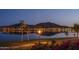 Scenic lakefront view with palm trees and city lights at 18135 W Hope Dr, Goodyear, AZ 85338