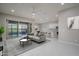 Bright, open-concept living room featuring tile floors, a ceiling fan, and seamlessly leading to the outdoor pool area at 18135 W Hope Dr, Goodyear, AZ 85338