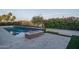 Lakeside pool area with cozy fire feature and meticulous landscaping for a resort-like experience at 18135 W Hope Dr, Goodyear, AZ 85338