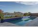 Stunning pool featuring an enticing lake view, enhanced by colorful flowers and lush greenery at 18135 W Hope Dr, Goodyear, AZ 85338