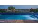 Inviting pool with dark blue tile and view of the nearby lake at 18135 W Hope Dr, Goodyear, AZ 85338