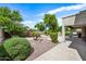 Well-manicured backyard with mature trees, decorative rock, and a covered patio at 19242 W Pasadena Ave, Litchfield Park, AZ 85340