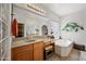 Bright and airy bathroom showcasing vanity with sink, soaking tub, and glass block window at 19242 W Pasadena Ave, Litchfield Park, AZ 85340