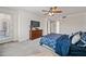 Spacious bedroom with ceiling fan, dresser and television; access to backyard visible through sliding glass door at 19242 W Pasadena Ave, Litchfield Park, AZ 85340