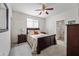 Well-lit bedroom with neutral walls and carpet, plus a ceiling fan and matching dark wood furniture at 19242 W Pasadena Ave, Litchfield Park, AZ 85340