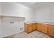 Laundry room with ample storage, countertop space, and tile flooring for easy maintenance at 19242 W Pasadena Ave, Litchfield Park, AZ 85340